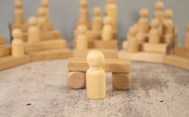 man speaks to supporters gathered on the bleachers, wooden silhouettes