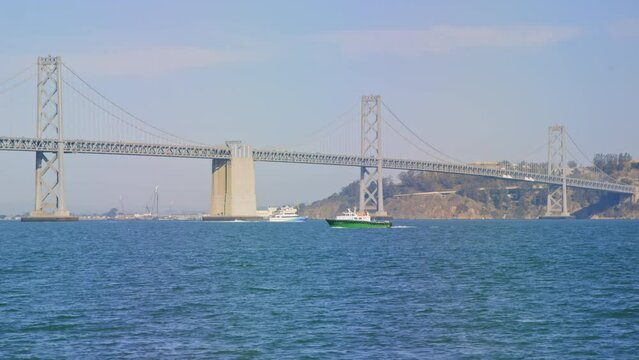 Boats pass in front of Bay Bridge in San Francisco Bay, slow motion