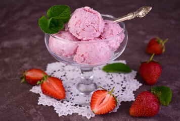 Strawberry ice cream and fresh strawberries on a gray background.
