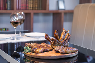 Grilled ribeye beef steak with red wine, herbs and spices on black table