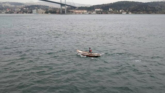 Turkey/Istanbul circa 2023: small boat with a man at the Bosphorus Strait