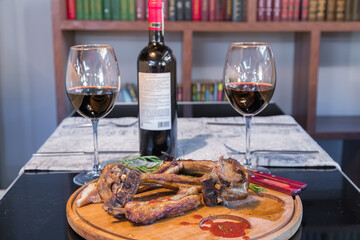 Grilled ribeye beef steak with red wine, herbs and spices on black table