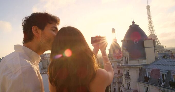 Couple, phone photography and Eiffel Tower on balcony, Paris or love on vacation, bond and romance. Young man, woman and profile picture for blog, holiday or summer in France, social media or terrace