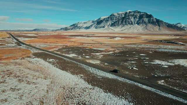 Aerial view - Drone shot tracking car driving on beautiful road with mountain, aerial scenic landscape from Iceland