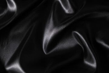 Silk fabric, abstract wavy black satin fabric background.