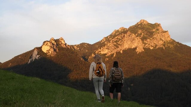 Two hikers walking in nature. Man and woman hiking in mountains. Sport challenge. Long way up to mountain peak
