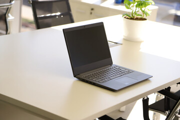  Laptop on desk with empty screen and copy space in an office. Laptop screen mockup. 