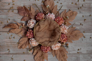 Newborn digital backdrop with wreath of handmade flowers and basket on wooden background. Newborn...