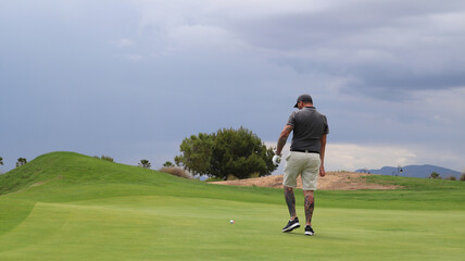 Professional one arm golfer hitting golf ball on the golf course. Concept of willpower of people with disabilities in sport

