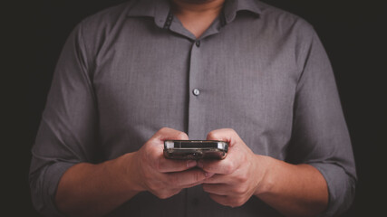 Businessman hold mobile phone in his hand while using internet for communication. Smartphone online application, information Technology and digital transformation concept.