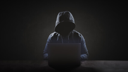 Hacker wear hood working with laptop when try to hacking into victim system for data or information...
