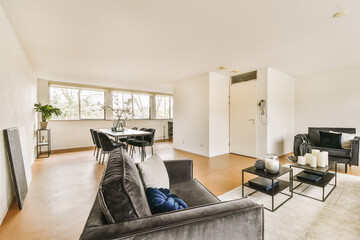 a living room with couch, coffee table and tv in the center of the room there is a large window that looks out into