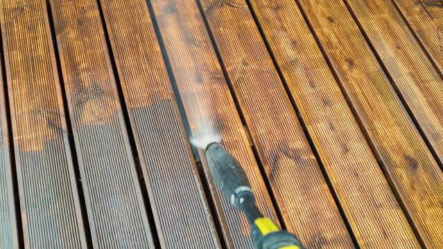 Cleaning wooden terrace decking before oiling and painting with a high pressure water cleaner