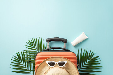 Dreamy holiday essentials. Orange suitcase seen from top view, beach essentials, stylish...