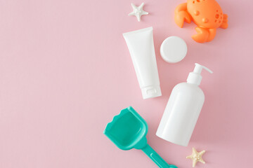 Concept for a sunscreen beauty mockup. Top view flat lay of sunscreen bottle, cosmetic tube, cream jar, beach toys and starfish on pastel pink background with space for advert or promotion