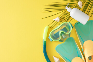 The concept of active summer vacation. Top view flat lay of cosmetic pump bottle, diving mask with snorkel, flippers, palm leaf and seashells on yellow background with empty space for promo or text