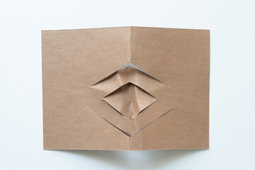 cut brown paper card with abstract chevron patterns on white