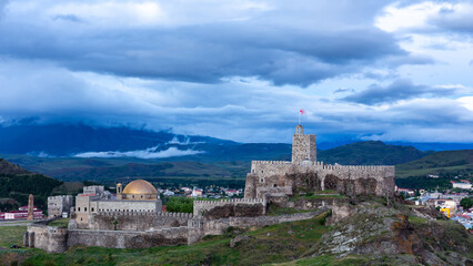 Fototapeta na wymiar Akhaltsikhe (Rabati) Castle, medieval fortress in Akhaltsikhe, Georgia during evening with dark cloudy sky in the background.