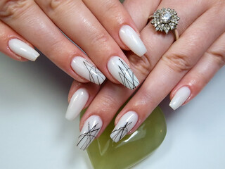 Womans nails hands with fashionable white manicure