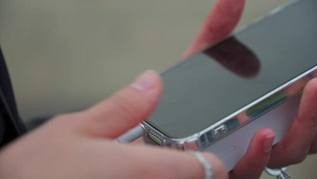 Hands connecting mobile phone to solar power bank closeup, Hands connecting mobile phone to solar power bank closeup. Connect the Powerbank to the Smartphone, Smartphone to the charging of external ba