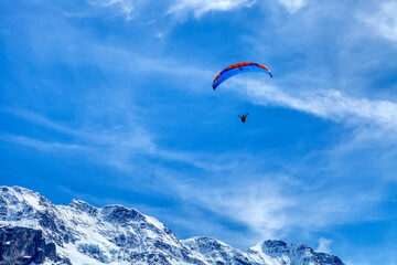 Fototapeta na wymiar Paraglider in the blue sky. The sportsman flying on a paraglider. Leisure sports activity in holiday