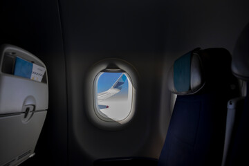 Window View From Passenger Seat On Commercial Airplane with blue sky, Concept of travel and air...