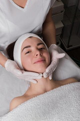 Fototapeta na wymiar Young woman enjoying massage in beauty salon.