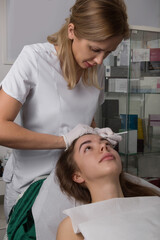 Obraz na płótnie Canvas cosmetologist marks the face before the Botox injection procedure