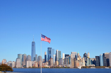 The American flag and the Hudson River and Manhattan in the background during the day