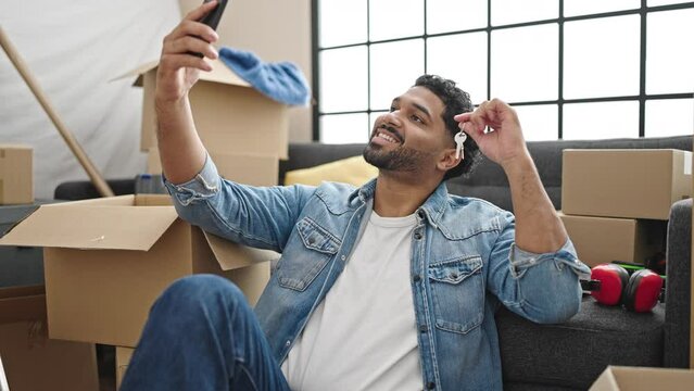 African american man make selfie by smartphone holding key at new home