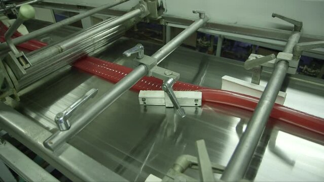 static close up shot of a caramel mass molding line in a candy factory