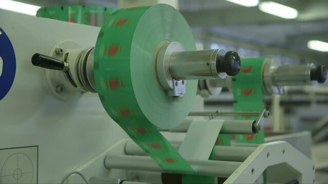 static close up shot of the cellophane roll of lollipop packaging spinning very quickly on the machine