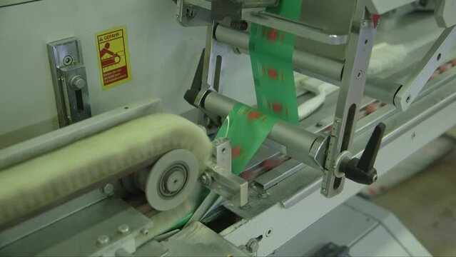 static close up shot of very fast lollipop packing machine in candy factory