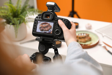 Food stylist taking photo of delicious meat medallion in studio, closeup