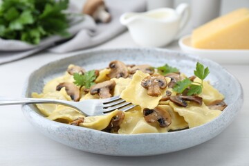 Delicious ravioli with mushrooms and fork on white table, closeup