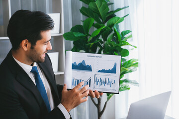 Professional businessman in black suit, present financial data or BI paper via laptop during online...