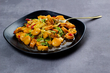 Saute sweet spicy sausage with black plate. Dark mood photography.