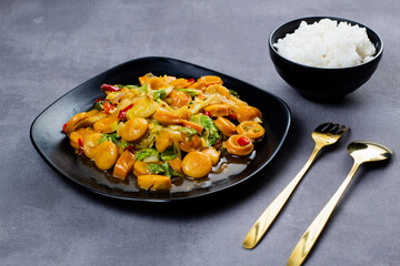 Saute sweet spicy sausage with black plate. Dark mood photography.