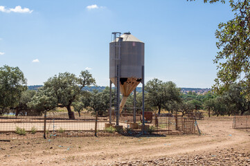 Silo de piensos oxidado en una explotación ganadera en zona de dehesa.