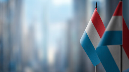 Small flags of the Luxembourg on an abstract blurry background - obrazy, fototapety, plakaty