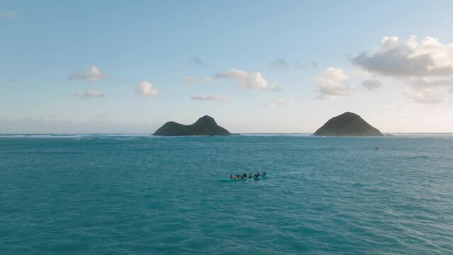 Hawaiian outrigger canoes sailing at scenic Na Mokulua islands, Oahu 4K. Aerial drone athletes people rowing in sports kayaks in tropical Hawaiian exotic destination with turquoise calm sea at sunrise