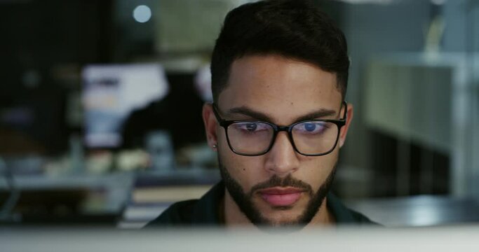 Computer, night and male developer working in the office developing an online website project. Technology, business and professional man coder doing coding research on a pc in workplace for overtime.