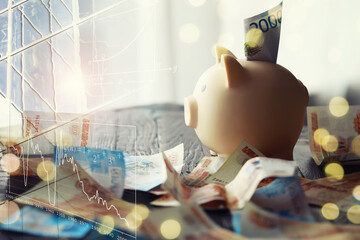 A piggy bank in the form of a pink pig stands on the wooden table with russians money, inscription...