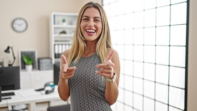 Young blonde woman business worker smiling confident pointing to camera at office