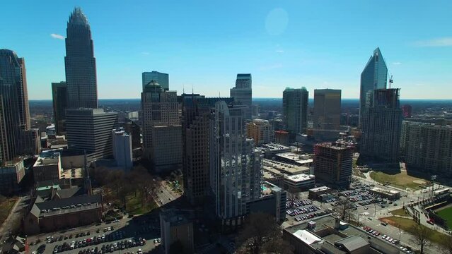 Aerial Panning Shot Of Cars On Streets By Buildings Against Sky, Drone Flying Over City On Sunny Day - Charlotte, North Carolina