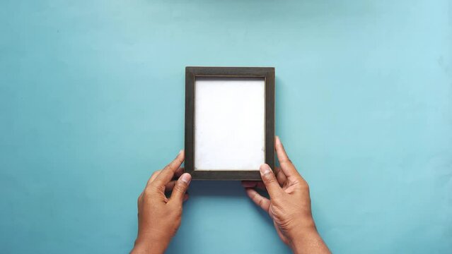 top view of hand putting empty frame on table 