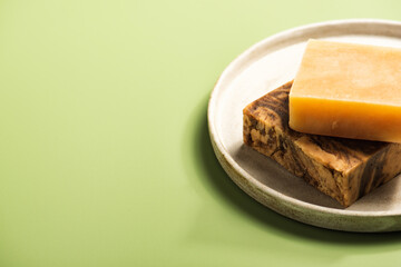 Handmade natural soap or shampoo bars on the concrete dish. Eco-friendly beauty skincare concept for small businesses. Zero waste gift on green background