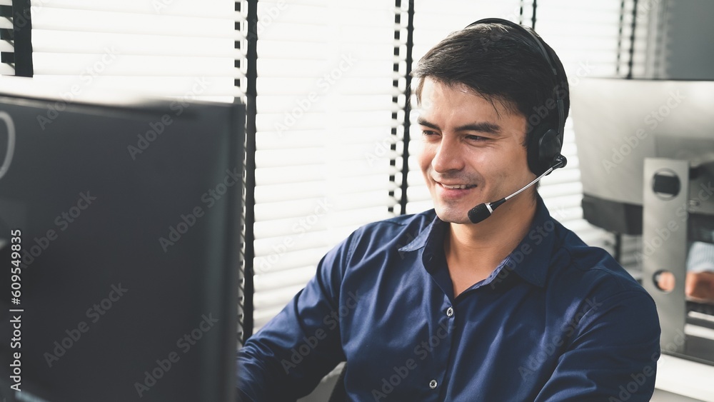 Aufkleber young competent asian male call center agent working at his computer while simultaneously speaking w