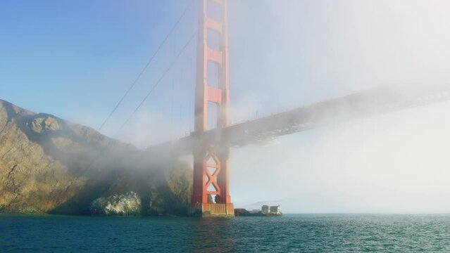 Imposing Golden Gate Bridge is covered in early morning fog, Pacific Ocean view