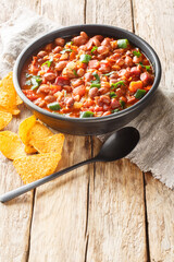 Frijoles charros or charros beans mexican traditional food with chorizo bacon and onions spicy food closeup on the bowl on the table. Vertical